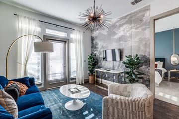 Farmers Branch apartment for rent - A modern living room with a blue sofa and a round coffee table.