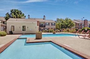 Midland apartment for rent - A refreshing outdoor swimming pool here at Cypress Pointe with clear blue water, wide pool decking, and surrounding lounge chairs for relaxing in the sun. A landscaped setting with nearby apartment buildings creates a welcoming, community-focused outdoor space.