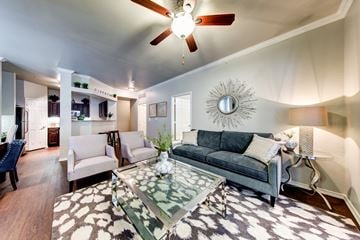Fort Worth apartment for rent - A living room with a grey couch and a glass coffee table.