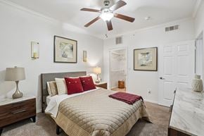 Fort Worth apartment for rent - A bedroom with a large bed and a ceiling fan.