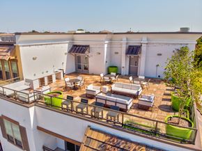 Rockwall apartment for rent - A rooftop terrace here at Florence at the Harbor with lounge seating, dining tables, bar-height chairs, and large planters, creating a spacious and social outdoor gathering area.