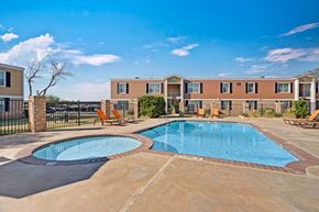 Odessa apartment for rent - A refreshing outdoor swimming pool here at Golden Crest with clear blue water, a spacious concrete deck, and surrounding lounge chairs, featuring a separate shallow pool area and a fenced courtyard setting under bright, sunny skies.