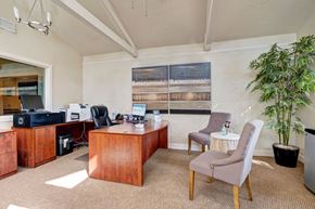 Midland apartment for rent - A room with a desk, chairs, and a potted plant.