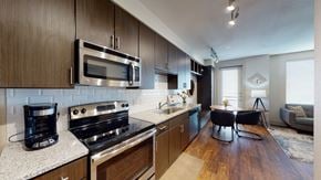 Allen apartment for rent - A modern kitchen with dark wood cabinets and stainless steel appliances.