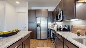 Allen apartment for rent - A modern kitchen with dark wood cabinets and stainless steel appliances.