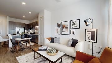 Allen apartment for rent - A modern living room with a white sofa, a coffee table, and a dining table with chairs.