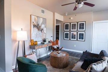 Fort Worth apartment for rent - A living room with a green chair and a painting on the wall.