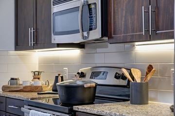 Austin apartment for rent - A kitchen with a stove top oven and a microwave above it.