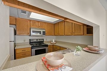 Odessa apartment for rent - A kitchen with wooden cabinets and a stove top oven.