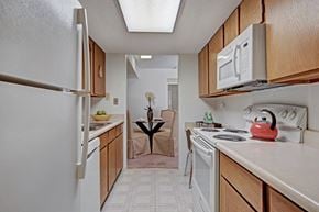 Midland apartment for rent - A kitchen with a white refrigerator, white microwave, and white oven.