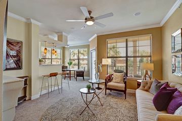 Odessa apartment for rent - A living room with a patterned carpet and a ceiling fan.