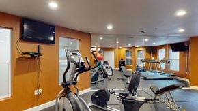 Salt Lake City apartment for rent - A gym with treadmills, exercise bikes, and a television.