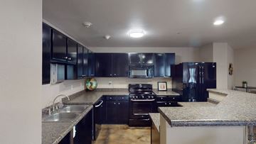 Salt Lake City apartment for rent - A modern kitchen with black cabinets and granite countertops.