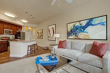 Sandy apartment for rent - A living room with a grey couch and a painting on the wall.