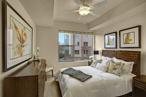Sandy apartment for rent - A bedroom with a large bed and a ceiling fan.