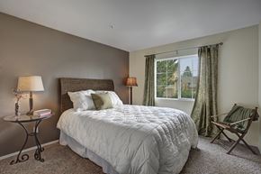Sandy apartment for rent - A bedroom with a large bed and a chair.