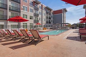 Salt Lake City apartment for rent - A pool area with red umbrellas and chairs.