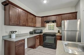 Salt Lake City apartment for rent - A kitchen with brown cabinets and a stainless steel refrigerator.