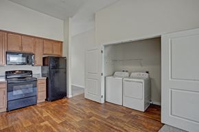 Wenatchee apartment for rent - A kitchen with wooden cabinets and a black refrigerator.