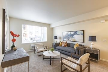 Wenatchee apartment for rent - A living room with a grey couch, a coffee table, and a painting on the wall.