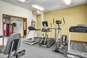 Covington apartment for rent - A gym with treadmills, elliptical machines, and a weight machine.
