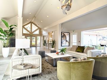 Mountlake Terrace apartment for rent - A living room with a white sofa, a yellow armchair, and a glass table with a lamp on it.
