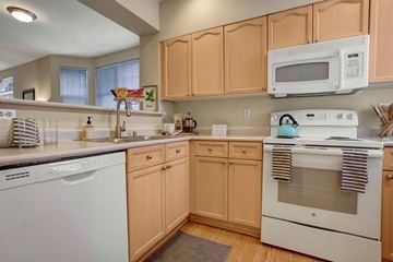 Kirkland apartment for rent - A kitchen with wooden cabinets and white appliances.