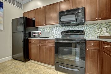 Kirkland apartment for rent - A kitchen with brown cabinets and black appliances.
