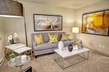 Bellevue apartment for rent - A living room with a grey couch, a white coffee table, and a painting on the wall.
