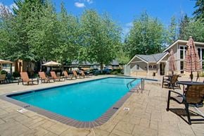 Federal Way apartment for rent - Large swimming pool surrounded by lounge chairs and umbrellas.