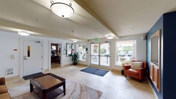 Shoreline apartment for rent - A living room with a brown coffee table and a red chair.
