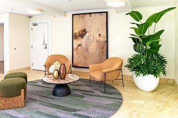 Shoreline apartment for rent - A living room with a chair, ottoman, and a large painting on the wall.