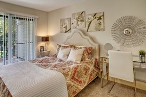 Renton apartment for rent - A bedroom with a large bed and a desk with a chair.