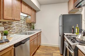 Renton apartment for rent - A kitchen with wooden cabinets and a black refrigerator.
