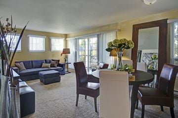 Renton apartment for rent - A living room with a blue couch and a round table with chairs.