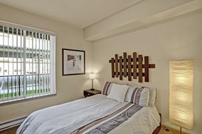Wenatchee apartment for rent - A bedroom with a bed, a lamp, and a picture on the wall.