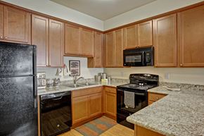 Wenatchee apartment for rent - A kitchen with wooden cabinets and granite countertops.