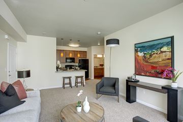 Moses Lake apartment for rent - A living room with a grey couch, a coffee table, and a painting on the wall.