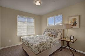 Moses Lake apartment for rent - A bedroom with a large bed and a small table with a lamp.