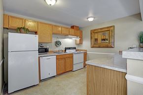 Federal Way apartment for rent - A functional kitchen here at Soundview with warm wood cabinets, white appliances, spacious countertops, and breakfast bar creating a practical and inviting cooking space.