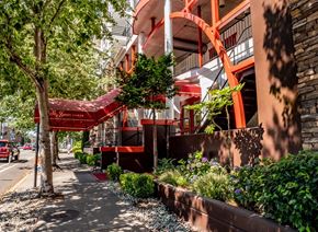 Seattle apartment for rent - A welcoming exterior entrance here at St. James Tower with covered awning, landscaped greenery, and modern architecture creating an inviting arrival experience.