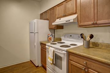 Seattle apartment for rent - A kitchen with a white stove and wooden cabinets.