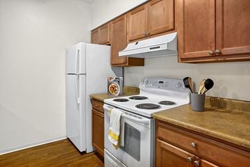 Seattle apartment for rent - A white refrigerator sits next to a stove in a kitchen.