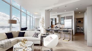 Seattle apartment for rent - A modern living room with a white sofa and a glass table.