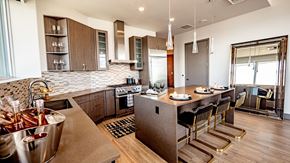 Seattle apartment for rent - A modern kitchen with a bar area and a dining table set for two.