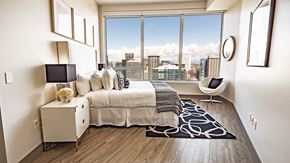 Seattle apartment for rent - A bedroom with a large bed and a view of the city.