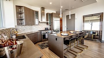 Seattle apartment for rent - A modern kitchen with a bar area and a dining table set for two.
