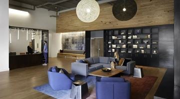 Kirkland apartment for rent - A woman is sitting on a blue couch in a modern living room.