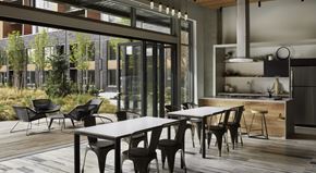 Kirkland apartment for rent - A stylish resident lounge here at Uptown at Kirkland Urban with modern dining tables, a sleek kitchen, and large glass doors opening to a landscaped patio, creating a bright, social space for relaxing or entertaining.