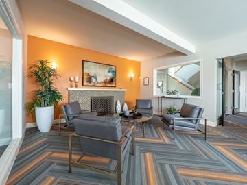 Lake Forest Park apartment for rent - A living room with grey chairs and a fireplace.